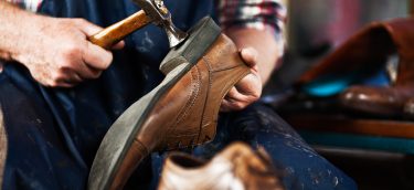 Close up of hands of old shoemaker