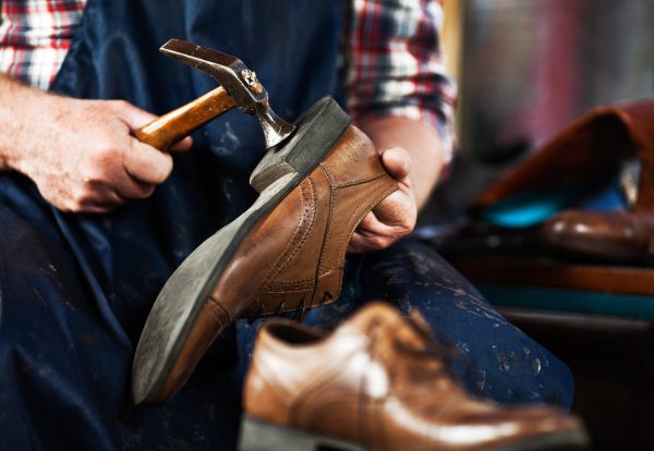 Close up of hands of old shoemaker